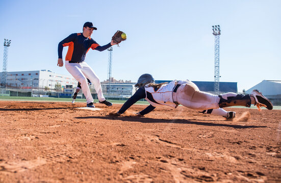 Baseball player sliding to the base during a baseball game