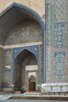 Ornate iwan portal of Bibi-Khanym Mosque in Samarkand covered in intricate geometric mosaic tilework. Ideal for travel publications, heritage articles, and architectural design references.