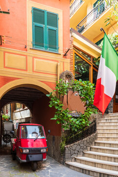 Italy, Liguria, Monterosso al Mare, Piaggio Ape riding through arched alley