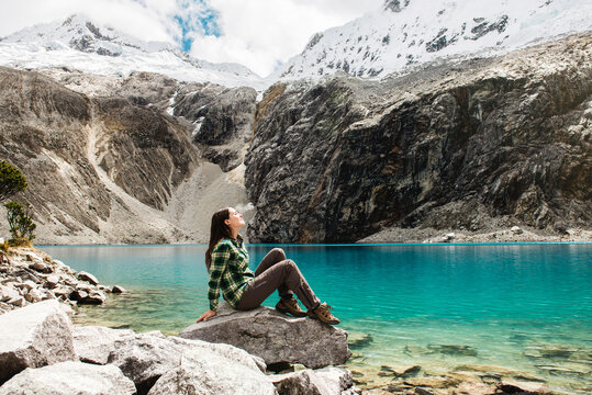 Peru, Huaraz, Huascaran National Park, woman relaxing after a trekking on lagoon, Laguna 69