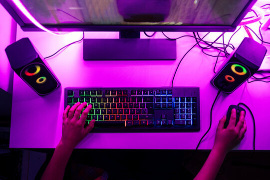 Boy with computer keyboard and mouse playing game on computer