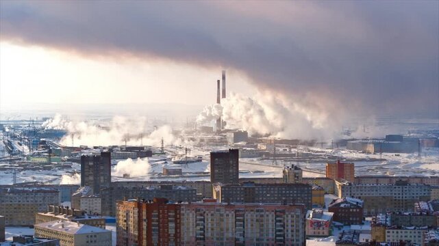 Industrial factory emitting toxic smoke into the air, covering a winter city in pollution