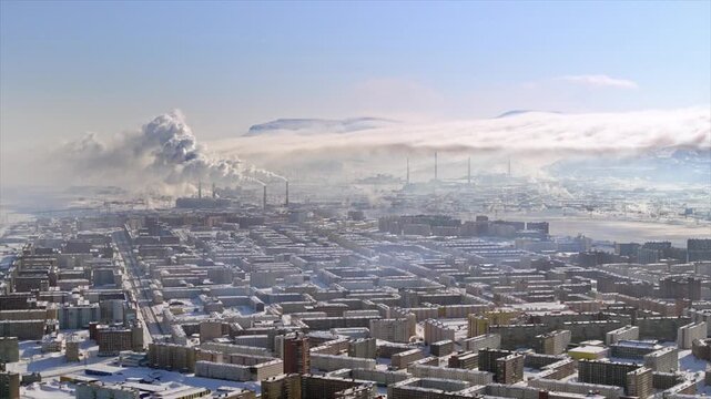 Aerial view of a polluted industrial city in Norilsk with factories emitting smoke