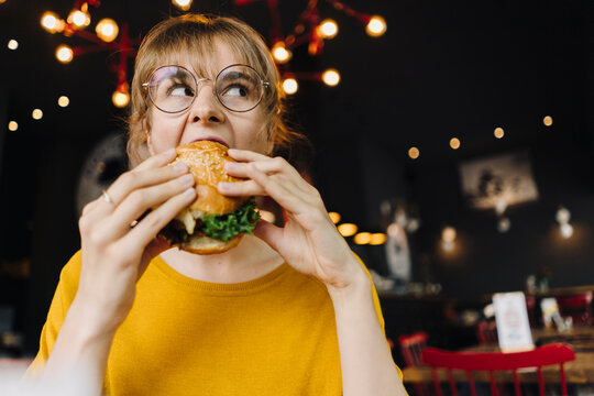 Young woman eating burger in a restaurant