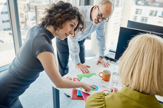 Colleagues discuss financial charts at a modern London office