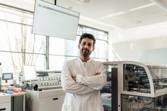 Confident doctor in white coat standing in modern laboratory