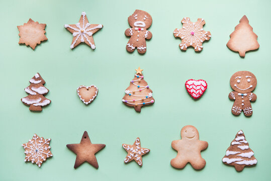 Rows of various gingerbread decorated with sugar icing on bright green ground