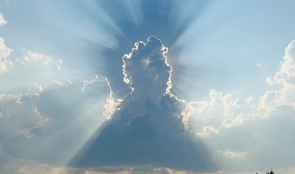 Majestic sunbeams or God rays breaking through cumulus clouds with a bright silver lining, inspiration nature concept.