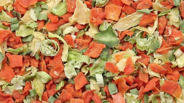 Pile of dehydrated shredded vegetables  (cabbage, green onions, and carrots) rotating slowly, Top view shot
