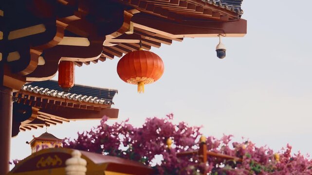 Traditional decoration on pagoda or temple in Chinese garden in Xian city. Chinese lantern under roof of terrace, unique Asian architecture, beautiful nature, blooming tree in springtime, calmness