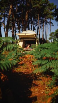Woman Relaxing in Open Vintage Campervan in Pine Forest &ndash; Van Life Lifestyle