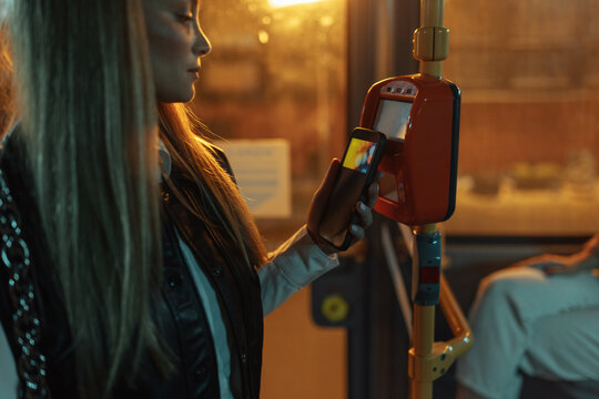 Woman paying bus fare using smartphone contactless