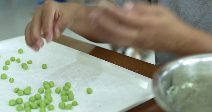 Close-up of the traditional dessert dough preparation. highlighting the intricate details of thai culinary art to create the authentic thai bua loi dessert.