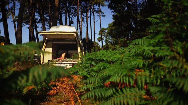 Woman Relaxing in Open Vintage Campervan in Pine Forest &ndash; Van Life Lifestyle
