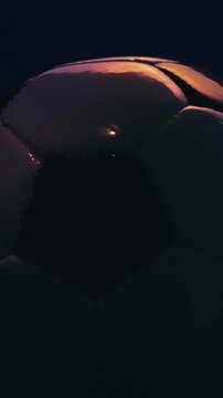 Rotating soccer ball close up on dark blue background