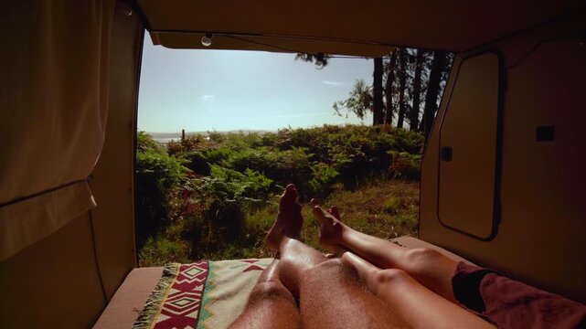 Cozy Van Life POV &ndash; Couple's Legs Resting in Open Campervan with Forest and Sea View