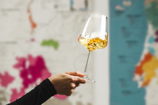 Close-Up of Wine Tasting Experience With Swirling Glass Against Map Background