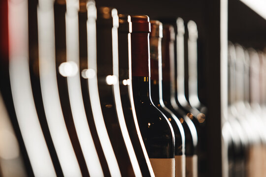 Close-Up of Elite Wine Bottles Lined Up on Shelf With Soft Lighting