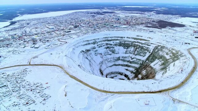 Huge open pit diamond mine near the city of Mirny in Yakutia, Russia during a cold winter day