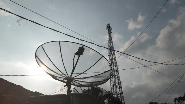 footage of satellite dish antennas and telecommunications towers with the evening sky in the background