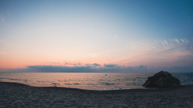 Sunset over the Mediterranean Sea seen from the beach during a summer evening. The photo was taken during a seaside holiday in Sicily, in the seaside village of Rodia