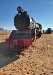 Powerful vertical close-up portrait of a historical Hijaz Railway steam locomotive in the desert of Jordan, near Wadi Rum. © 和美 浅川