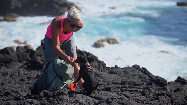 Female Hiker Trekking with a Miniature Pinscher Dog Along a Volcanic Trail in the Lanzarote Badlands