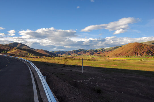 Scenic road with vast mountains and clear sky in the distance