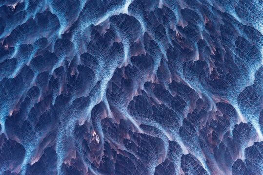 Aerial abstract view of wave-sculpted sand ripple patterns on a black volcanic beach, south coast Iceland.