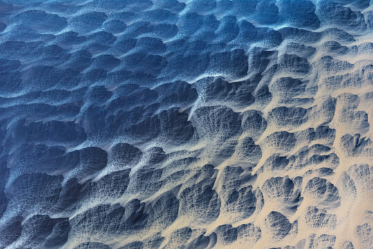 Aerial abstract view of wave-sculpted sand ripple patterns on a black volcanic beach, south coast Iceland.