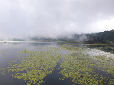 The mist descending from the mountains to the lake in the morning