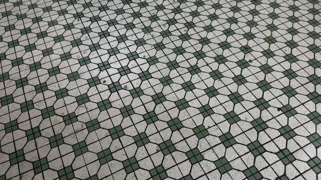 Wide establishing top-down view of vintage mosaic tiles flooring composed of simple, repeating geometric patterns inside a traditional Singapore Kopitiam (coffee shop).