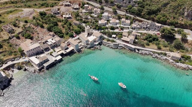 Aerial view of Limeni village turquoise waterfront old stone house towers built in 16th and 17th centuries on a sunny day, Peloponnese