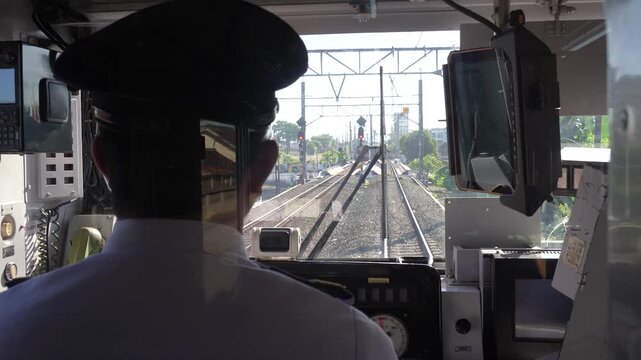 Train driver operating commuter train from cabin viewpoint