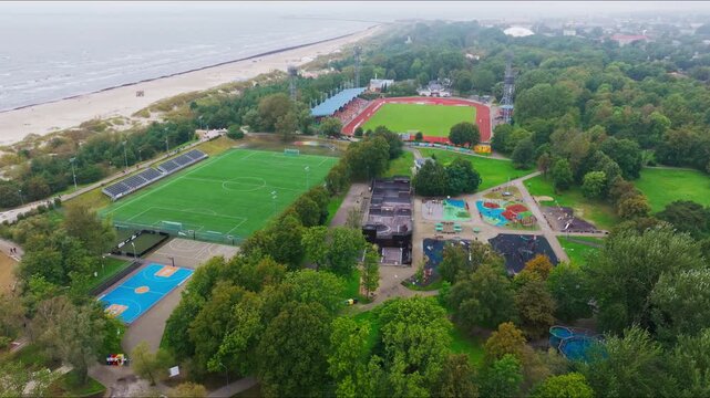 Drone flies above Liepaja stadium and training field beside the Baltic coastline