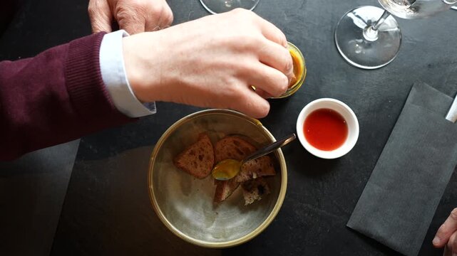 Closeup of bread served with two different sauces, hands visible around dish.