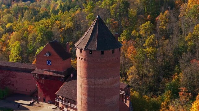 Camera pans left, moves closer to main tower of Turaida Castle in autumn, Latvia