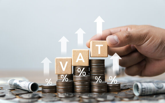 Value Added Tax (VAT) in the digital economy, represented by the letters VAT stacked on top of a growing pile of coins, signifies the management of tax costs.
