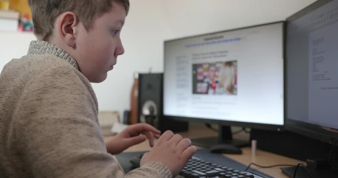 Kid Boy Use Desktop Computer for Study Typing and Reading. 4K 10-bit