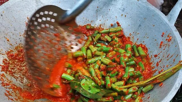 Stir frying long green beans in wok