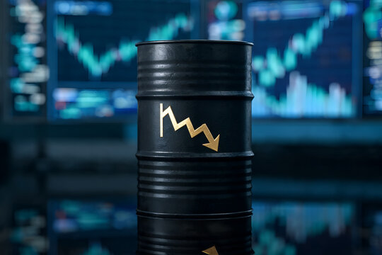 Single oil barrel with downward arrow on monitor screen showing stock market chart