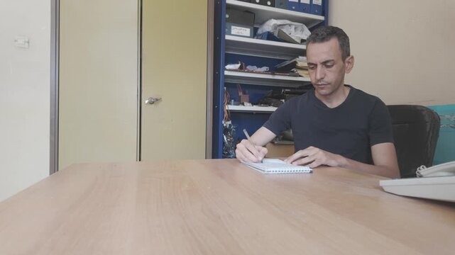 young businessman hand writing on a block note
