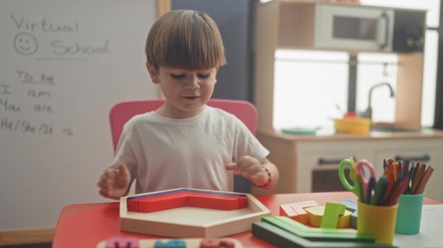 Boy using hands to sort a wooden shape sorter on a red table beside a whiteboard that reads virtual school in a home classroom; concentration learning play.