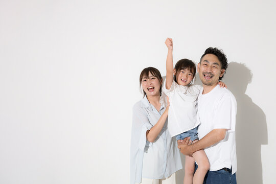 白背景で仲良し笑顔の家族・幸せなファミリーライフと健康的な暮らし　半袖夏休みイメージカメラ目線　拳をあげてガッツポーズやレッツゴー！