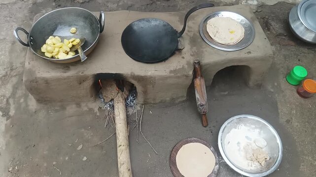 Traditional Indian clay stove with firewood burning in village kitchen