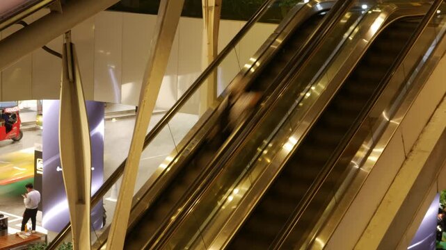 Editorial July 06 2026 &mdash; Shoppers and Commuters Riding Escalator Up to BTS Skytrain Skywalk Station, EmQuartier Shopping Mall Bangkok Thailand