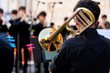 Young musician playing trombone with brass band in outdoor street concert © Alfonso Soler