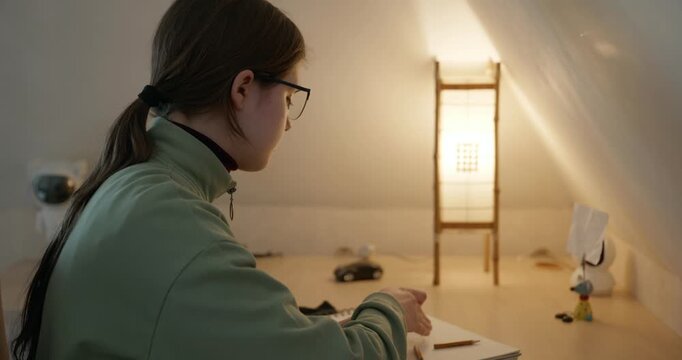 Girl Draw Pictures With Pencil on Desk Table in Bedroom at Home. 4K 10-bit