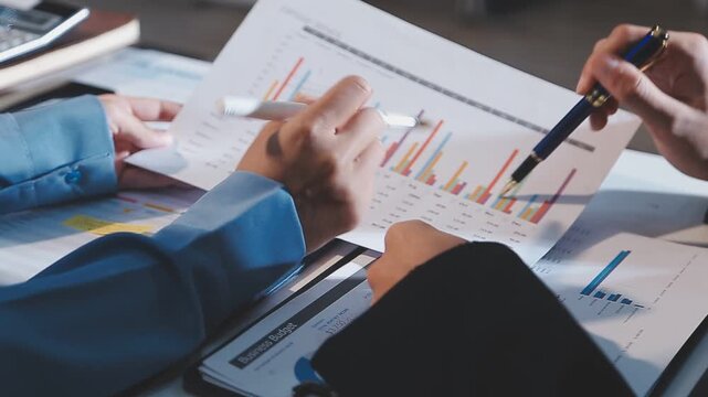 Close up of businesswomen or accountant using calculator calculate while working analytic business report on the workplace, Planning financial and accounting concept.