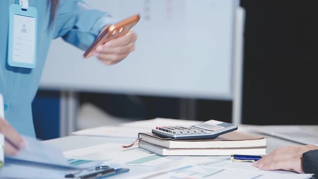 Close up of businesswomen or accountant using calculator calculate while working analytic business report on the workplace, Planning financial and accounting concept.